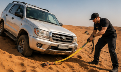 Recovery vehicle pulling a car out of sand